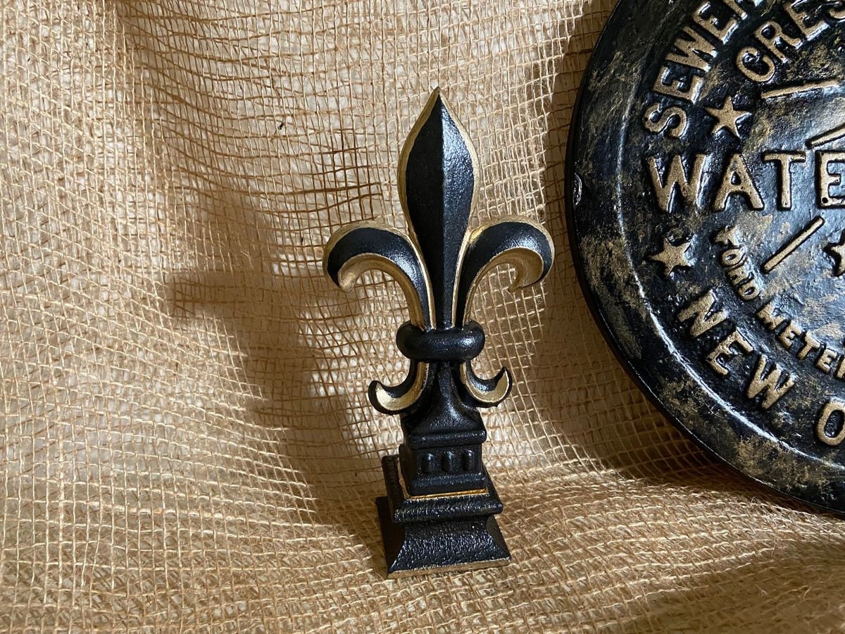 5 1/2” and 7 1/4” high cast iron Fleur de lis on pedestal. Beautifully hand painted with metallic gold accents