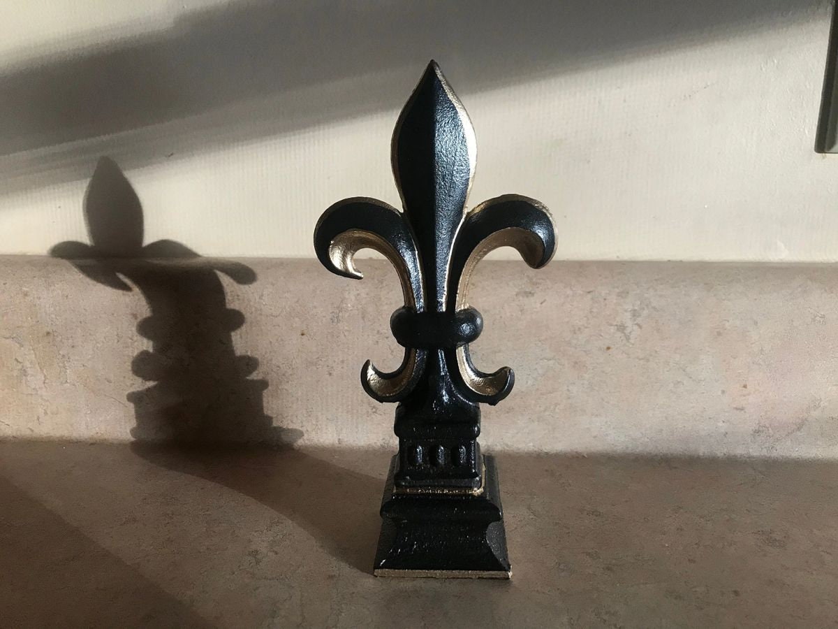 5 1/2” and 7 1/4” high cast iron Fleur de lis on pedestal. Beautifully hand painted with metallic gold accents