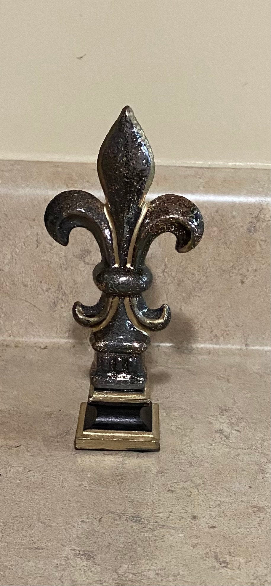 5 1/2” and 7 1/4” high cast iron Fleur de lis on pedestal. Beautifully hand painted with metallic gold accents